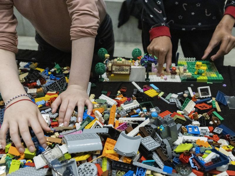 Børnehænder, der hygger med at bygge LEGO.