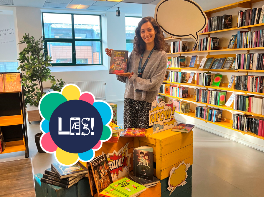 Bibliotekar står med bog i hånden og holder booktalk. 